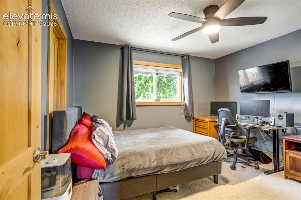 Image 22 of 50: Bedroom featuring a ceiling fan with integrated lighting, wood-finish inter