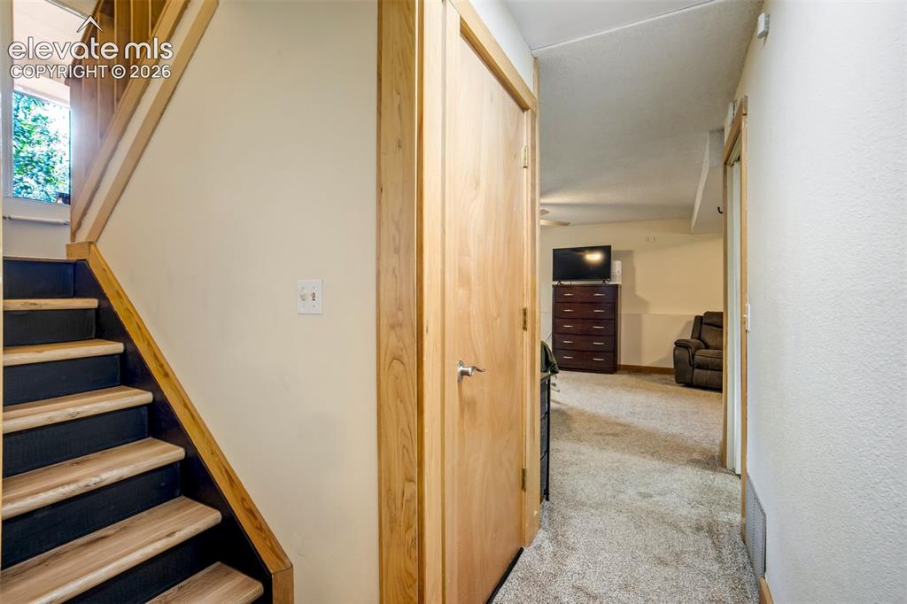 Image 25 of 50: Wood-finish staircase with black risers and wood railings