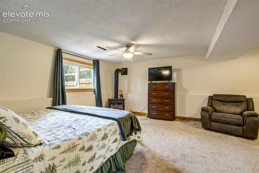 Image 26 of 50: Carpeted room featuring a ceiling fan with integrated lighting, a window wi