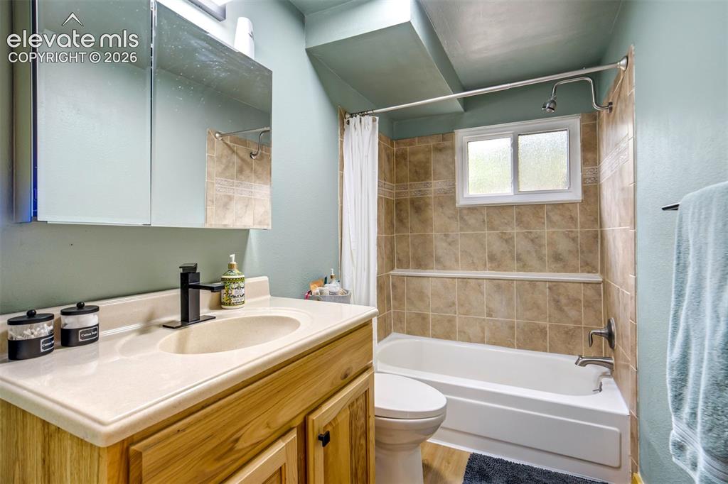 Image 32 of 50: Bathroom featuring a built-in vanity with a light-colored countertop and un