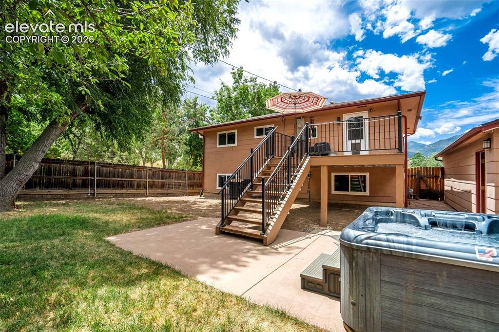 Image 37 of 50: Backyard featuring a two-story residence with an upper-level deck, exterior