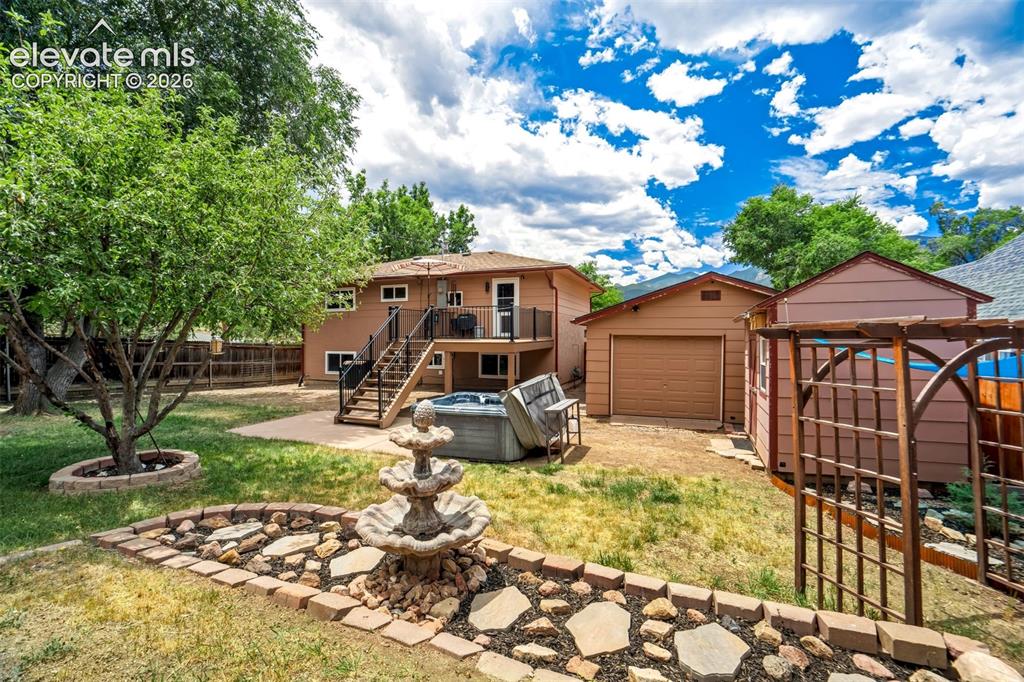 Image 40 of 50: Expansive backyard featuring a tiered fountain, stone-lined landscaping, an