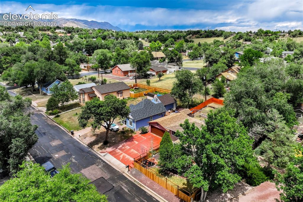 Image 5 of 50: Residential property with a red-toned driveway and a blue exterior, featuri