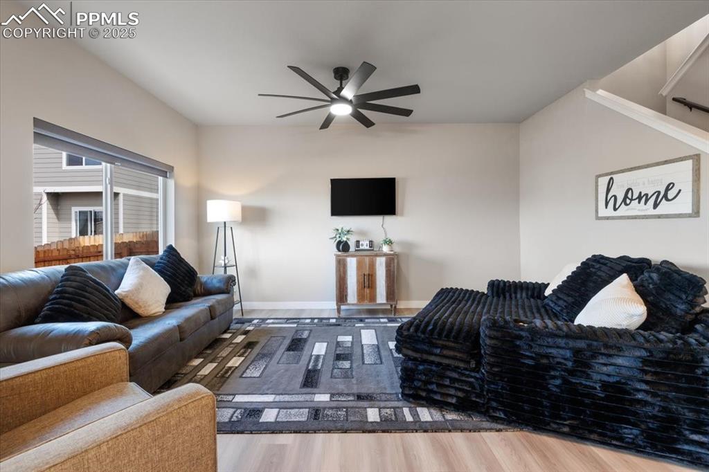 Image 9 of 26: Living area featuring baseboards, a ceiling fan, and wood finished floors