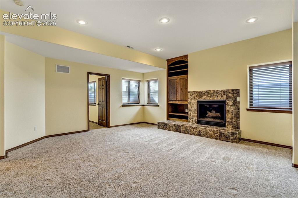 Image 32 of 46: basement fam. rm w/view of gas fireplace and bdrm 6 entrance