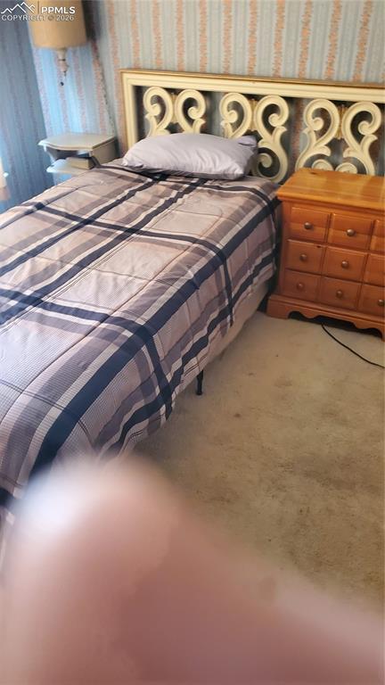 Image 19 of 36: Bedroom with wallpapered walls and light colored carpet