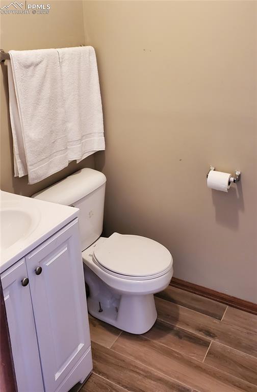 Image 22 of 36: Half bath with dark wood-style floors and vanity