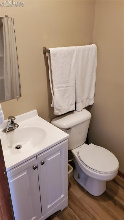 Image 26 of 36: Half bath with vanity and dark wood finished floors