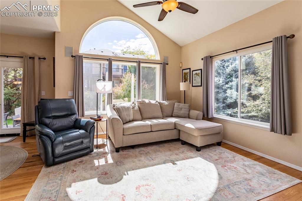 Image 16 of 47: Living area featuring a ceiling fan, wood finished floors, plenty of natura