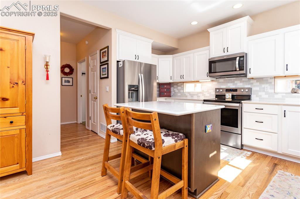 Image 21 of 47: Kitchen with appliances with stainless steel finishes, decorative backsplas