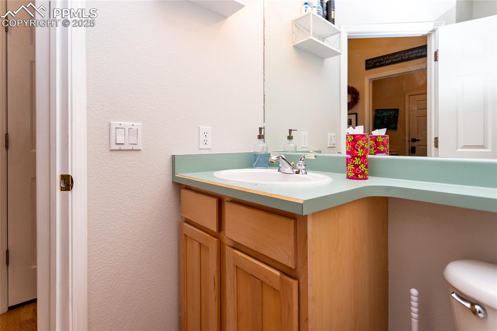 Image 23 of 47: Half bathroom with vanity and a textured wall