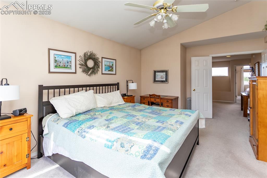 Image 28 of 47: Bedroom featuring light colored carpet, lofted ceiling, and a ceiling fan