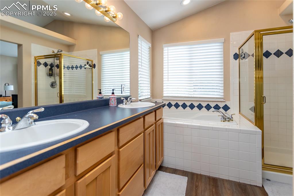 Image 31 of 47: Bathroom featuring dark wood-style flooring, a stall shower, double vanity,