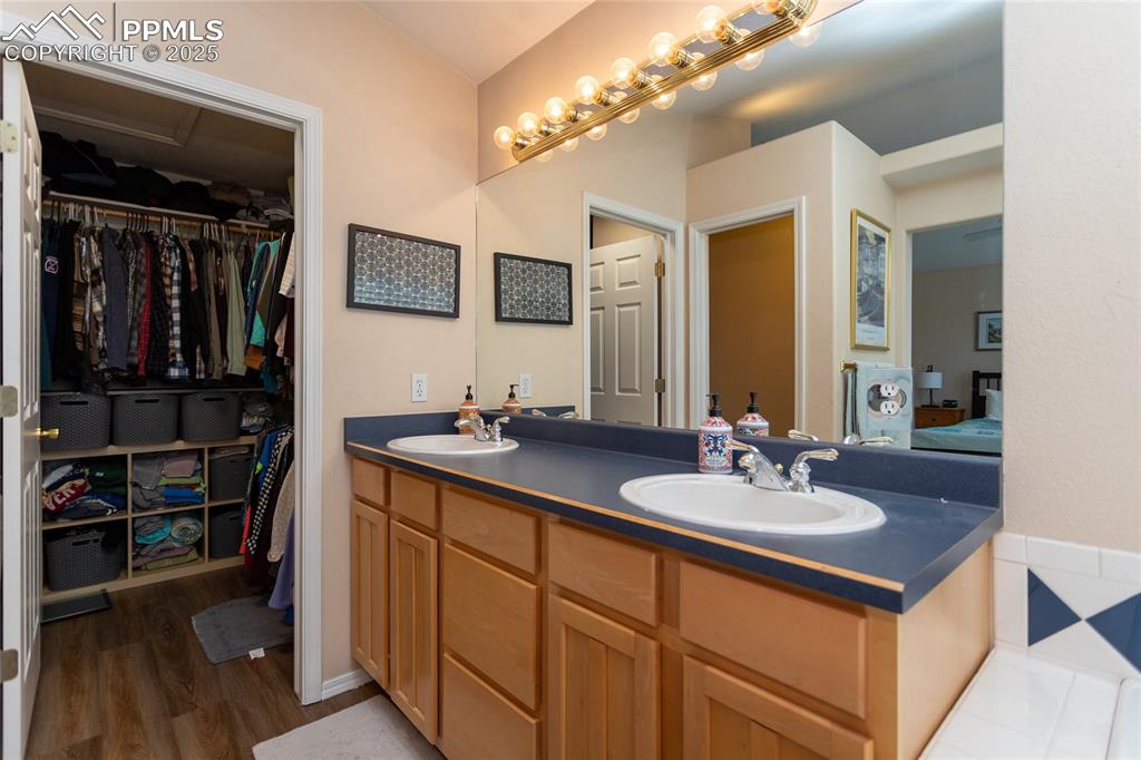 Image 32 of 47: Bathroom with double vanity and a walk in closet