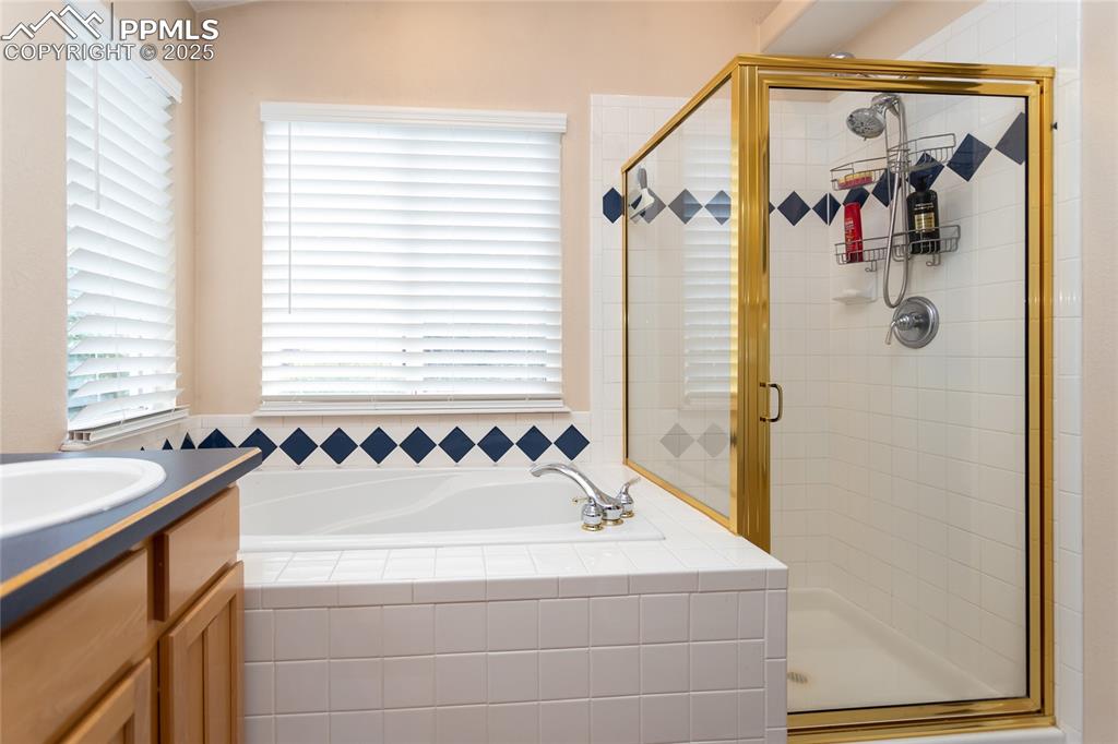 Image 33 of 47: Bathroom with vanity, a garden tub, and a stall shower