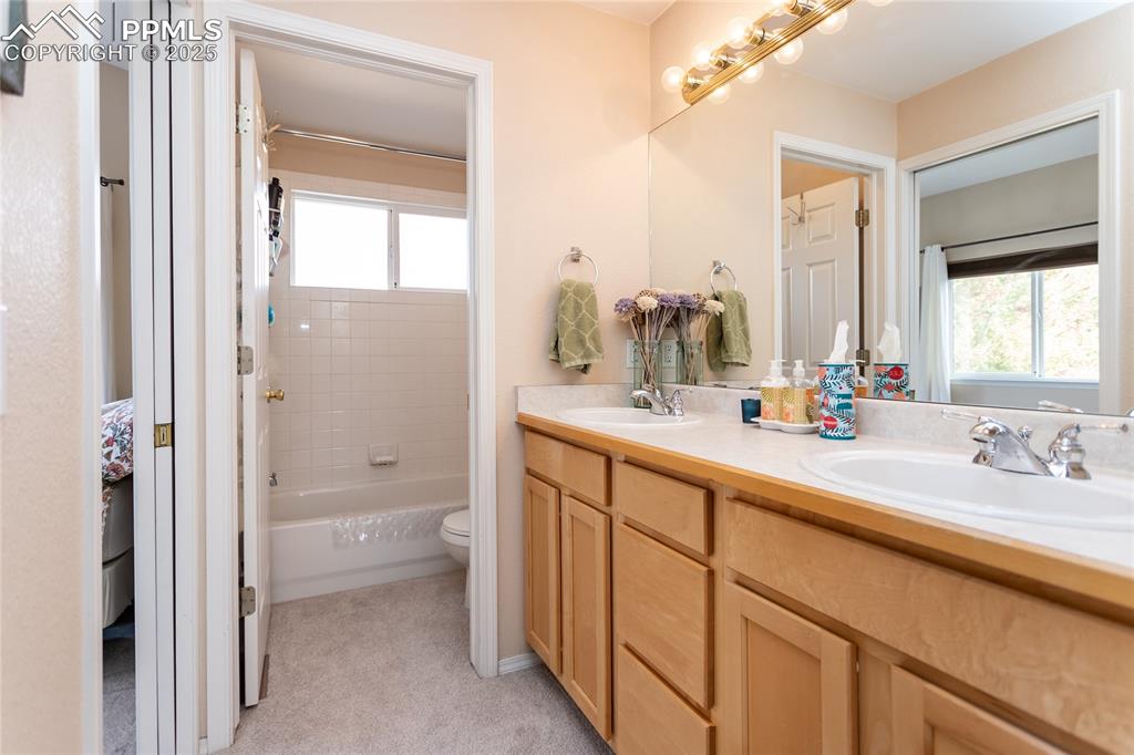 Image 35 of 47: Full bathroom featuring double vanity and shower / washtub combination