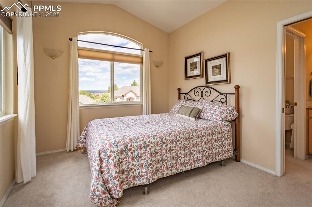 Image 36 of 47: Bedroom featuring light carpet and lofted ceiling