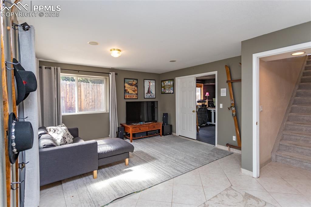Image 38 of 47: Living area with stairway and light tile patterned flooring