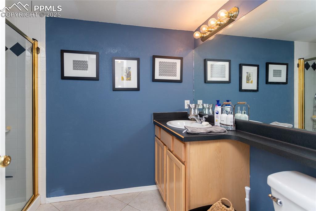 Image 41 of 47: Bathroom featuring a shower stall, vanity, and light tile patterned floorin