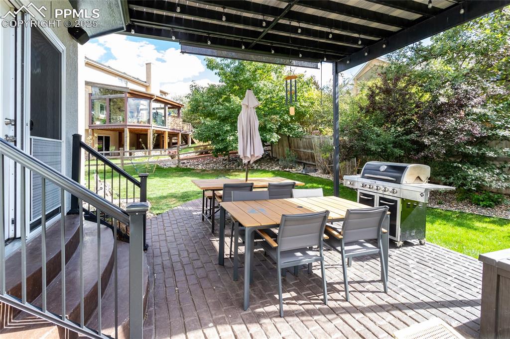 Image 43 of 47: Brick patio featuring a outdoor dining area, a fenced backyard,and grilling