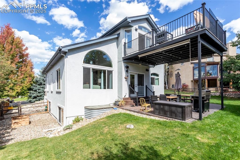 Image 44 of 47: Rear view of property featuring a patio area, stucco siding, and a lawn