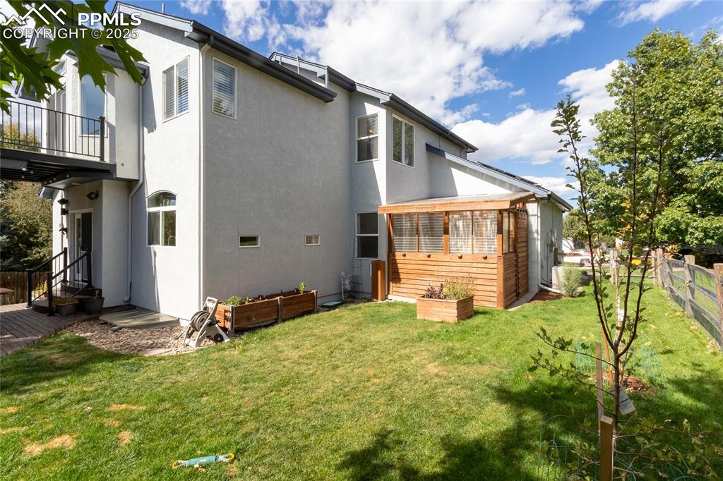Image 47 of 47: Rear view of house featuring stucco siding and a balcony