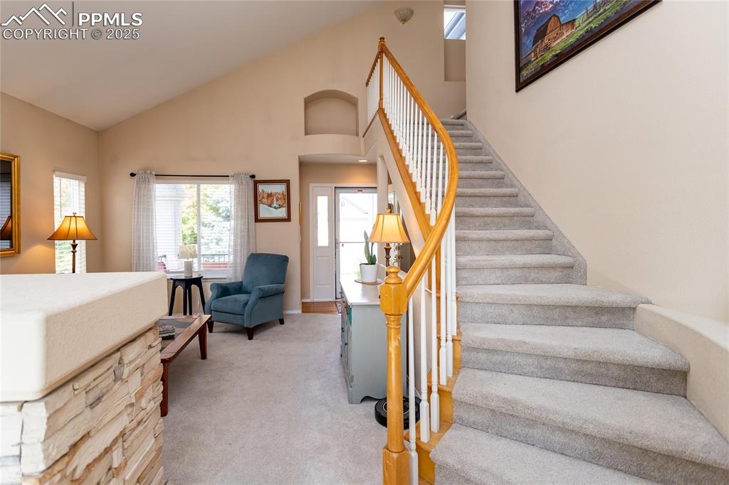 Image 9 of 47: Stairs with carpet floors and high vaulted ceiling