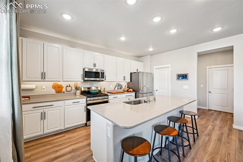 Image 18 of 50: Kitchen with stainless appliances, large island with breakfast bar, quartz 
