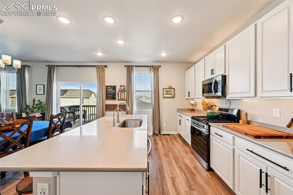 Image 21 of 50: Kitchen with stainless appliances, large island with breakfast bar, quartz 