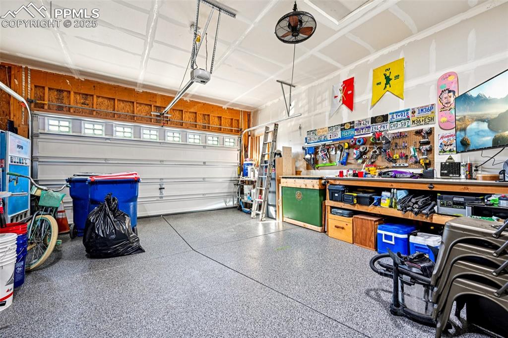 Image 46 of 50: 2 car garage with workshop and newly epoxied flooring