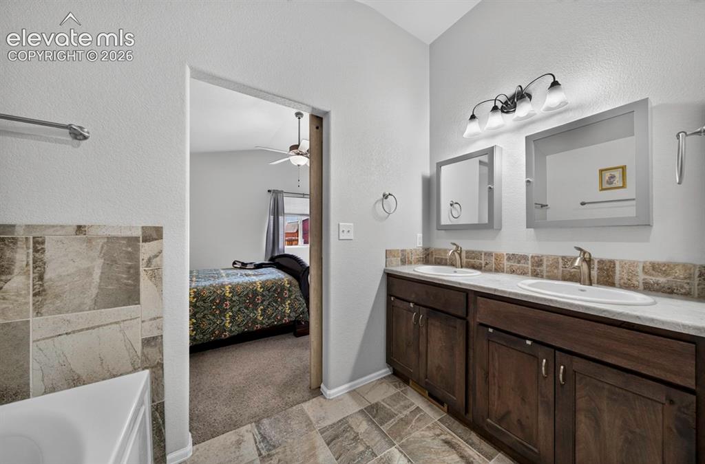 Image 12 of 40: Dual vanity with integrated sinks and brushed nickel faucets set atop a dar