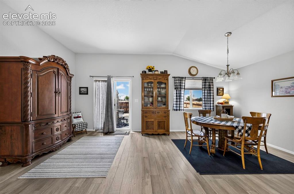 Image 14 of 40: Vaulted ceilings accentuate the spacious interior, featuring wood-finish fl