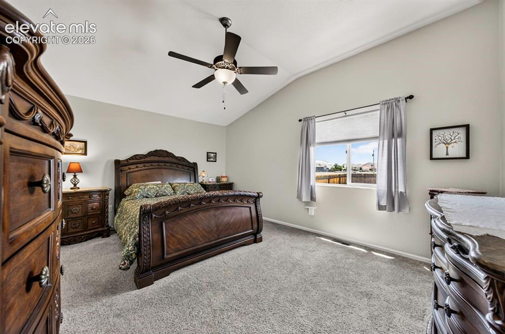 Image 20 of 40: MB Carpeted room featuring a vaulted ceiling and a ceiling fan with integra