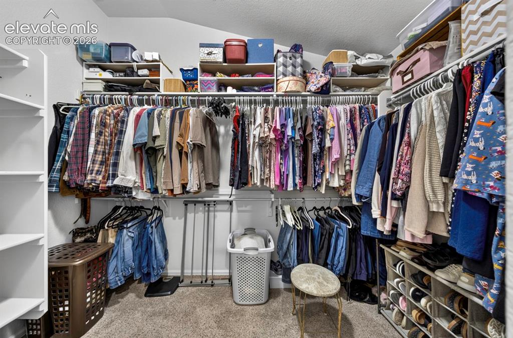Image 22 of 40: Custom closet system featuring multiple hanging rods, integrated shelving,