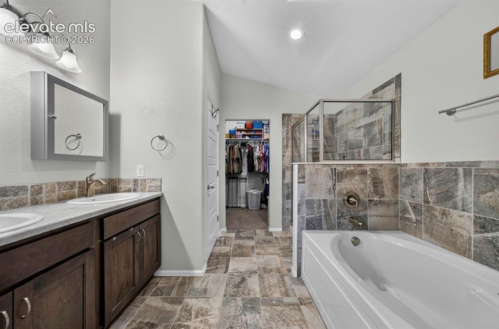 Image 23 of 40: Bathroom featuring a double vanity with dark wood-finish cabinetry, a frame