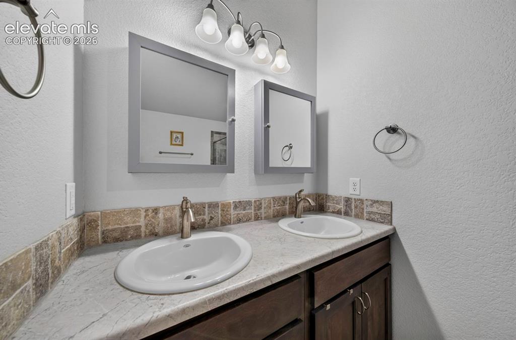 Image 24 of 40: Dual vanity featuring oval undermount sinks with brushed nickel single-hand