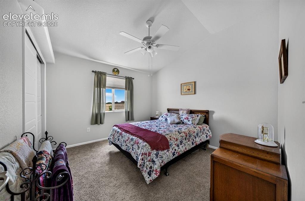 Image 27 of 40: Inviting BR #2 room featuring a vaulted ceiling with a ceiling fan, carpet