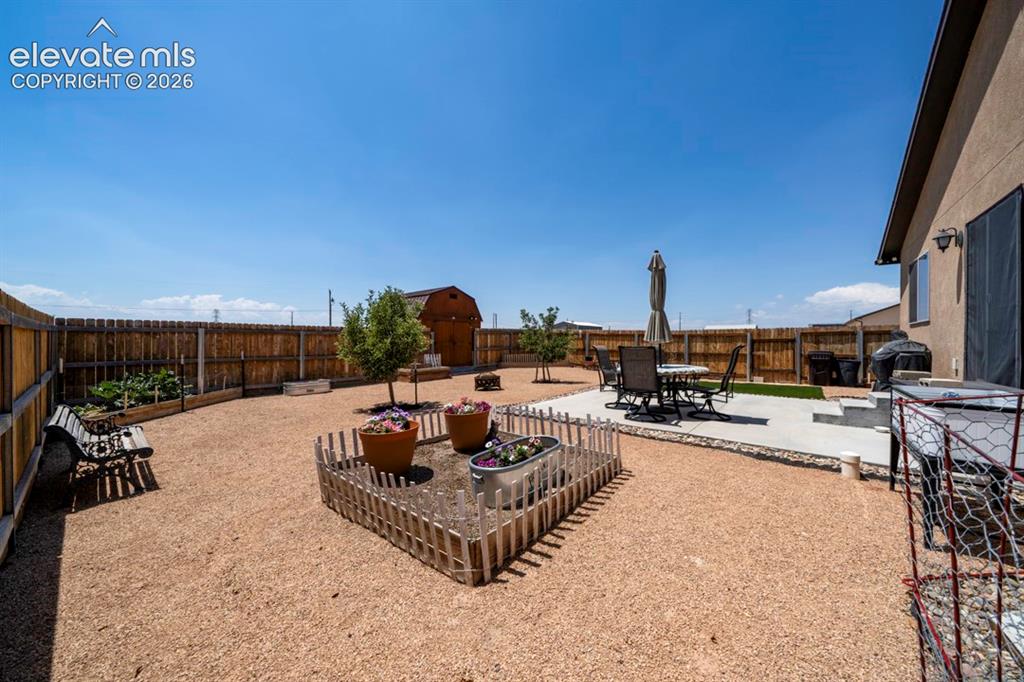 Image 37 of 40: Spacious backyard featuring a privacy fence, gravel landscaping, a concrete