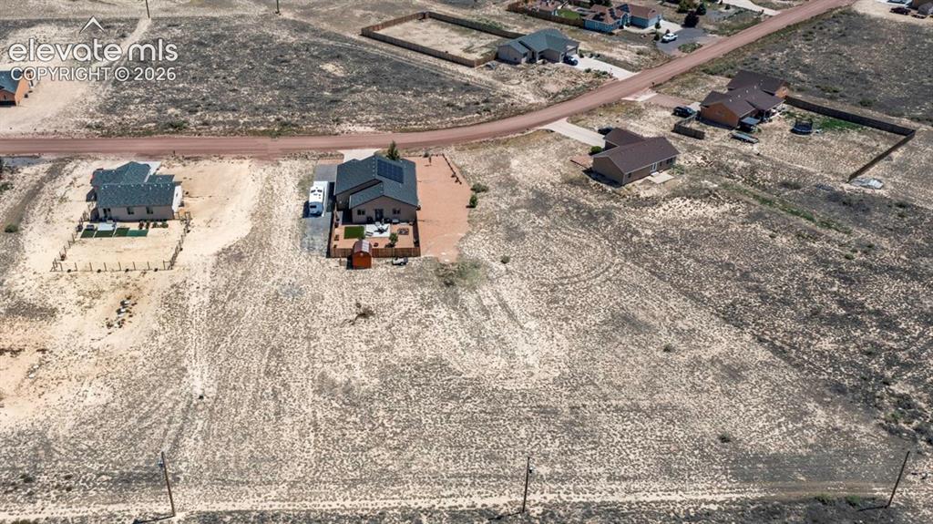 Image 4 of 40: Single-story residence featuring a dark shingle roof with solar panels and