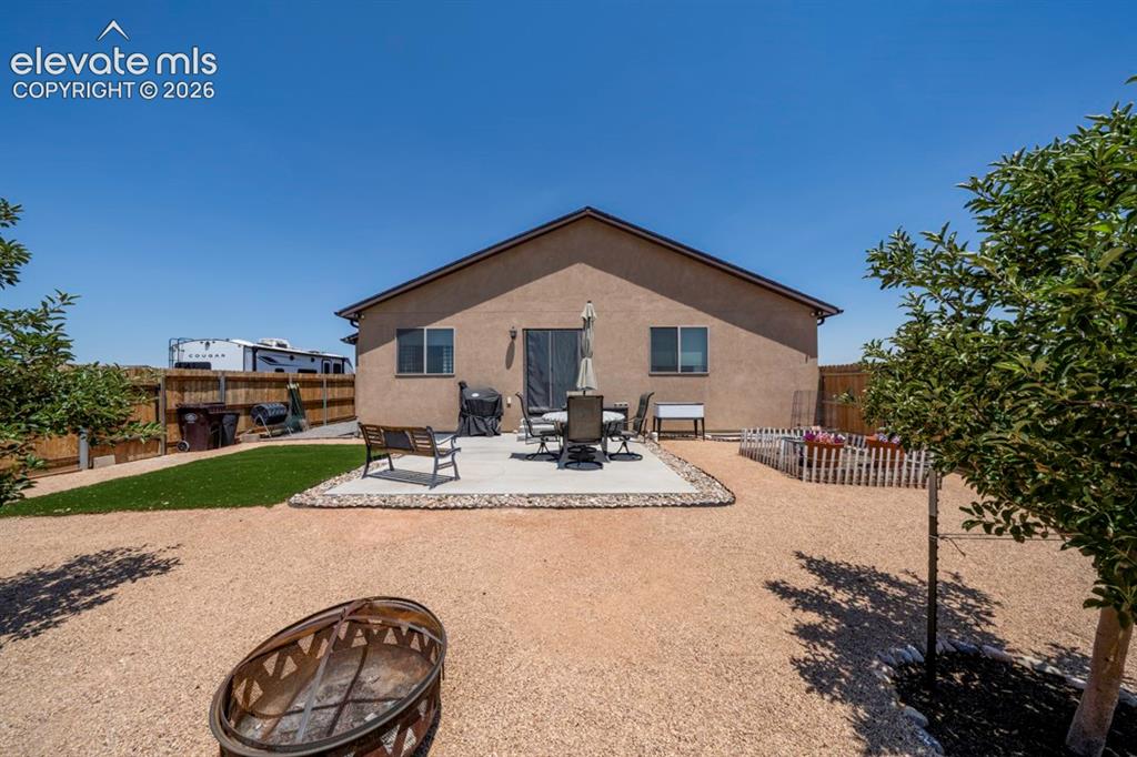 Image 40 of 40: Rear exterior featuring a stucco finish and a gabled roofline