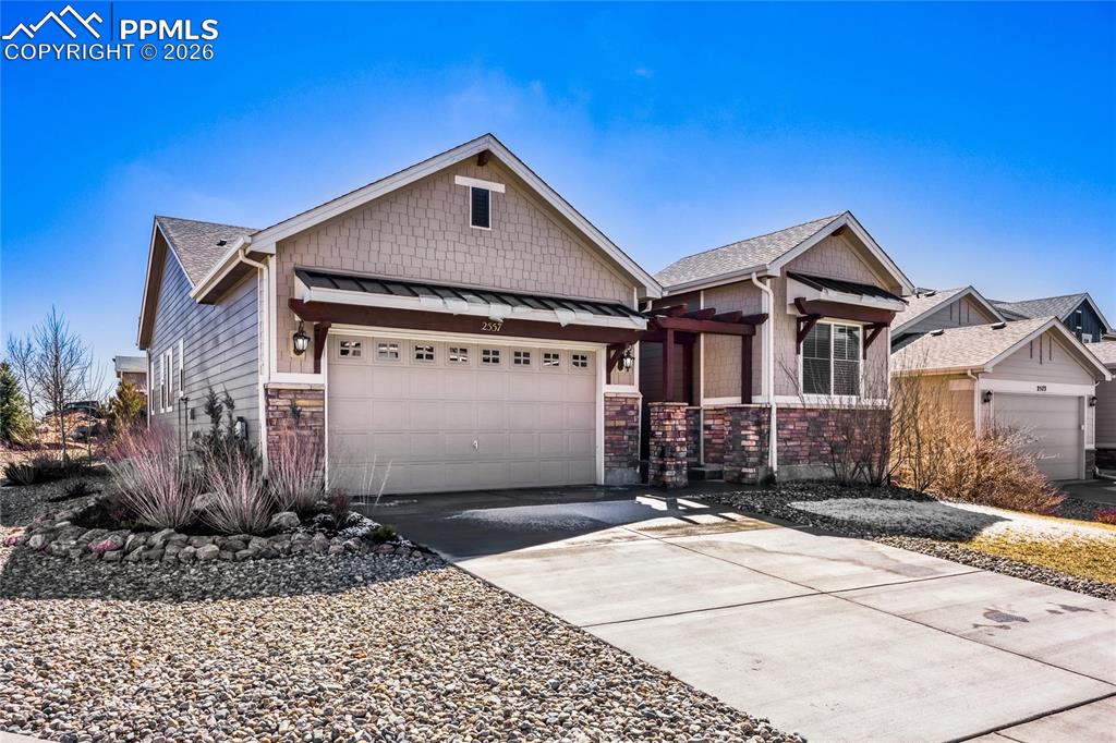 Image 2 of 30: Craftsman-style home with a standing seam roof, an attached garage, concret