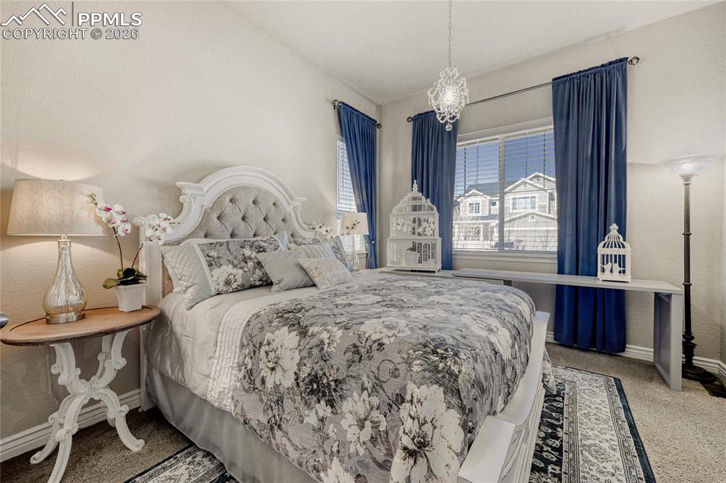Image 22 of 30: Guest Bedroom featuring light colored carpet chandelier and walk-in closet 