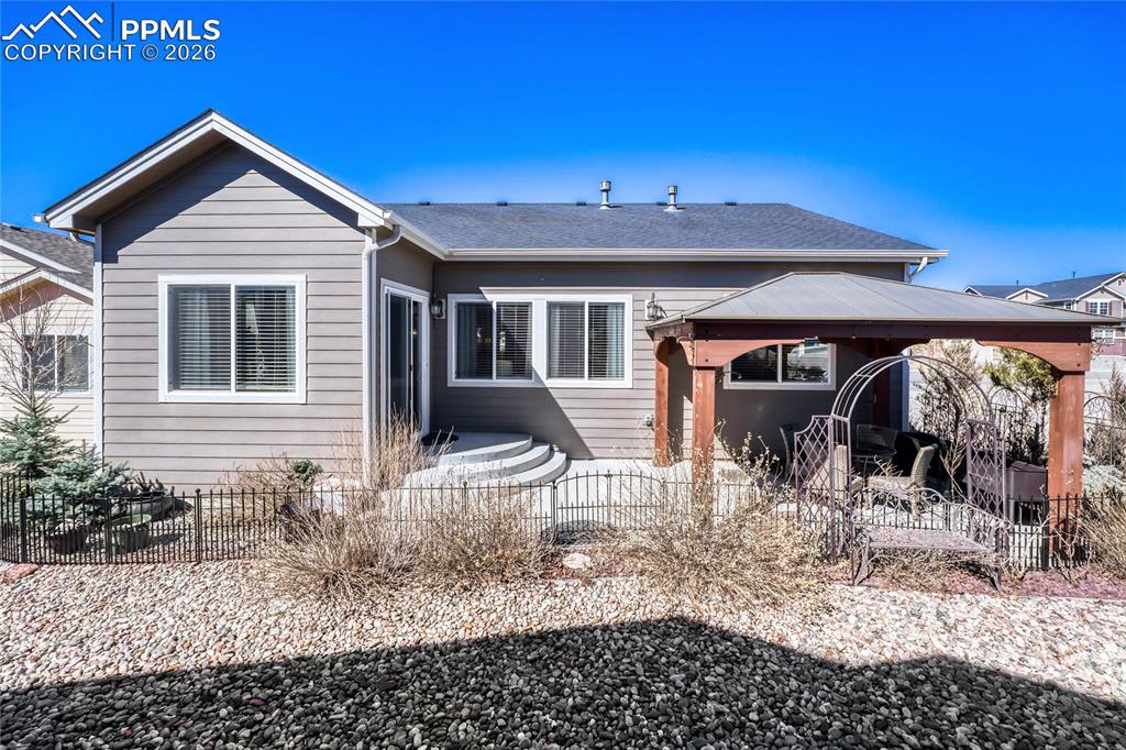 Image 26 of 30: Rear view of property with a gazebo, a patio, and a shingled roof