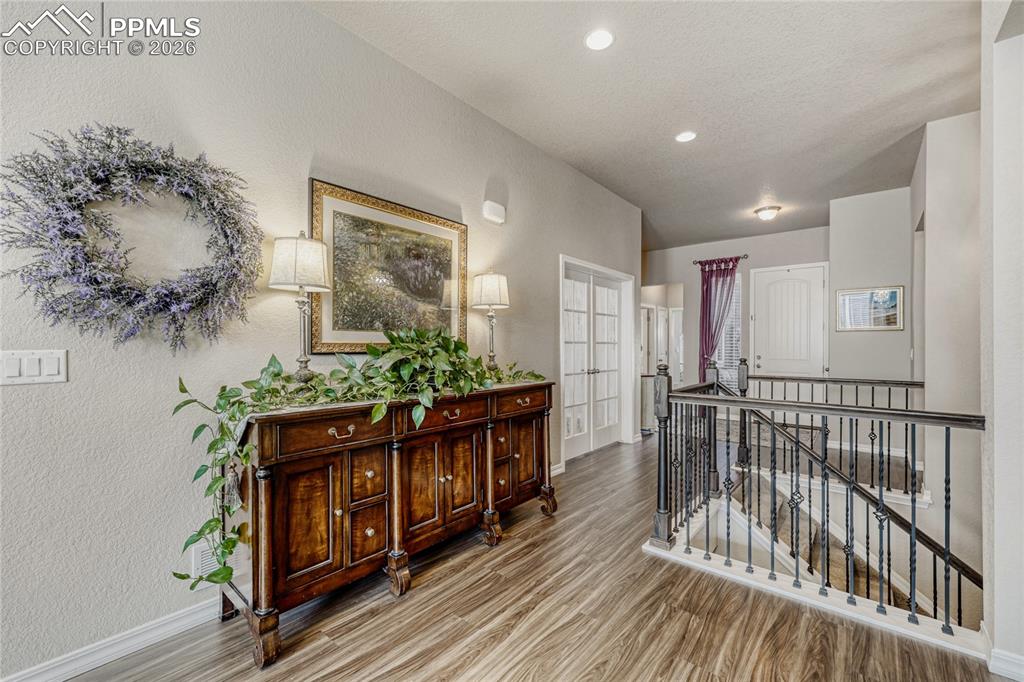 Image 5 of 30: Hall with an upstairs landing with LVP floors and recessed lighting