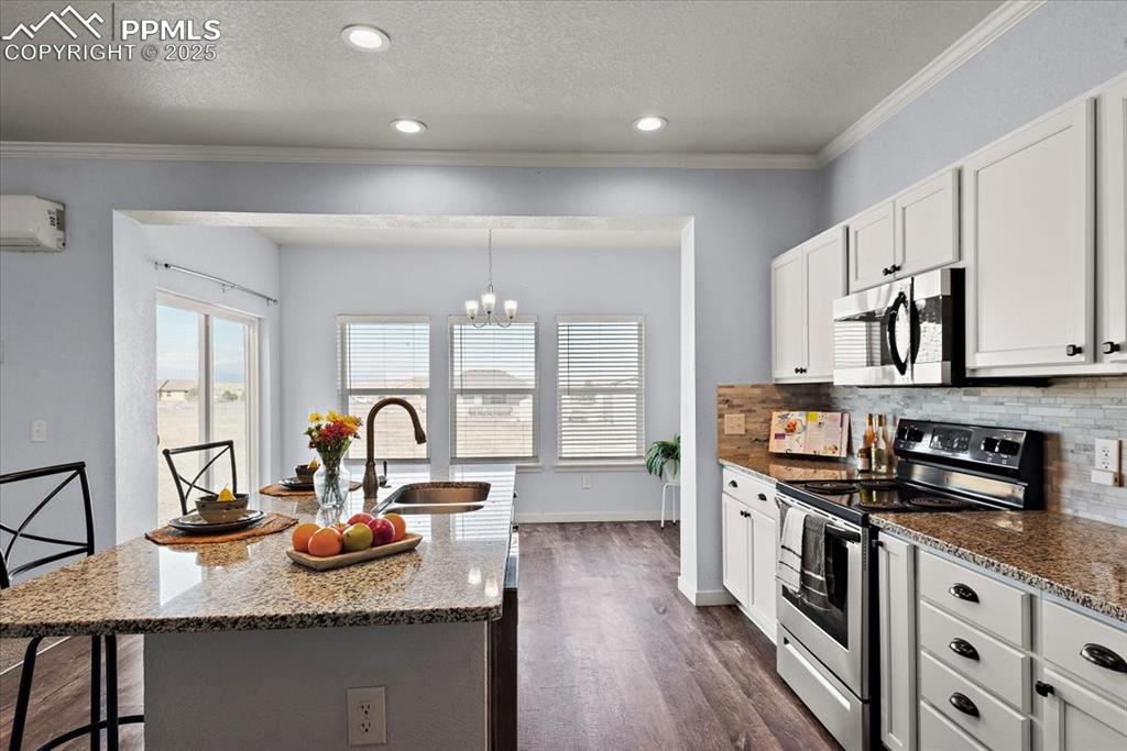 Image 17 of 33: Kitchen with stainless steel appliances, a sink, a kitchen island with sink