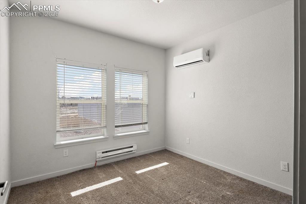 Image 20 of 33: Unfurnished room featuring baseboards, baseboard heating, carpet flooring,