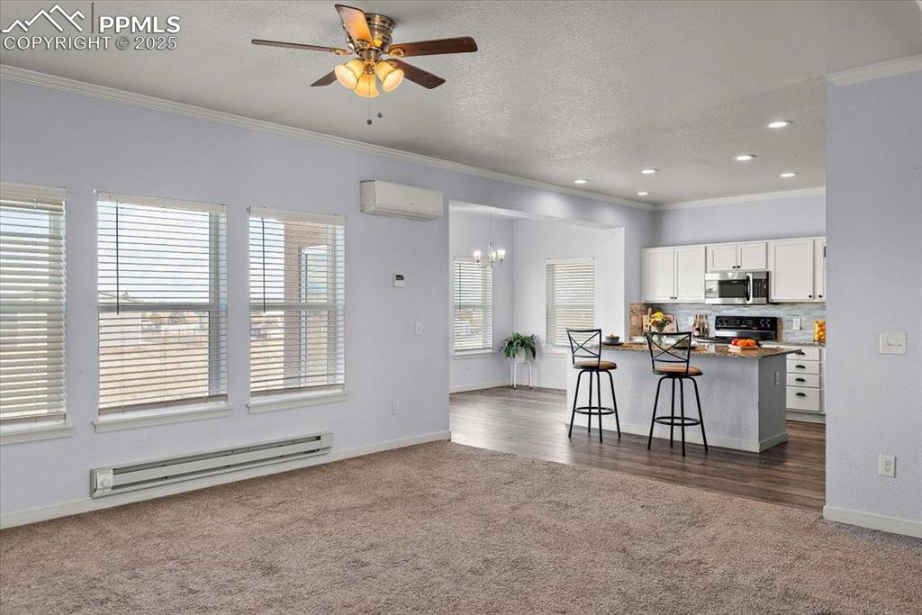 Image 9 of 33: Kitchen featuring range with electric cooktop, white cabinets, stainless st