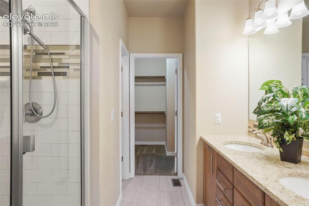Image 15 of 48: Master Bath with double vanity, quartz counter and tile floor
