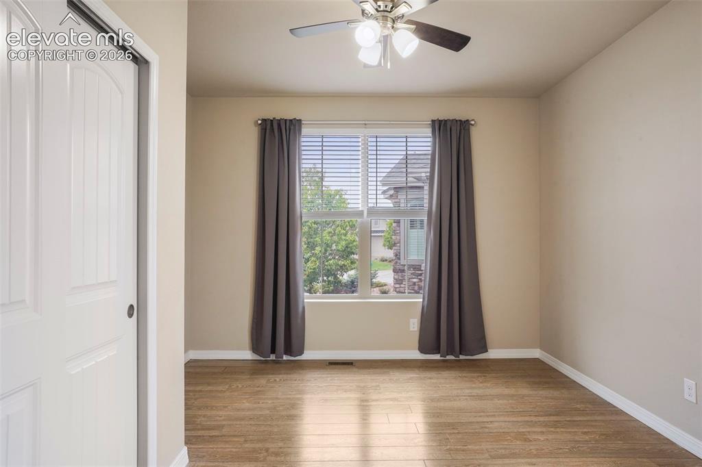 Image 18 of 48: Bedroom #2 on main level with wood laminate floor and view of open space