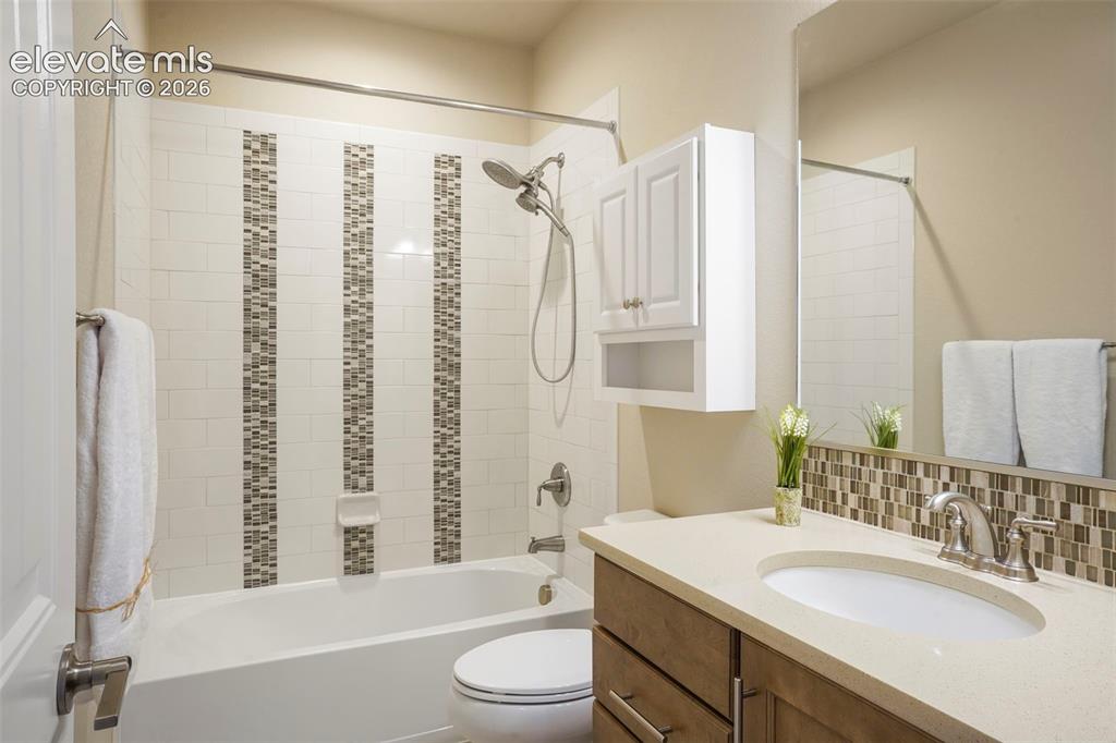 Image 27 of 48: Basement Full Hall Bath with quartz countertop and upgraded shower tile wit